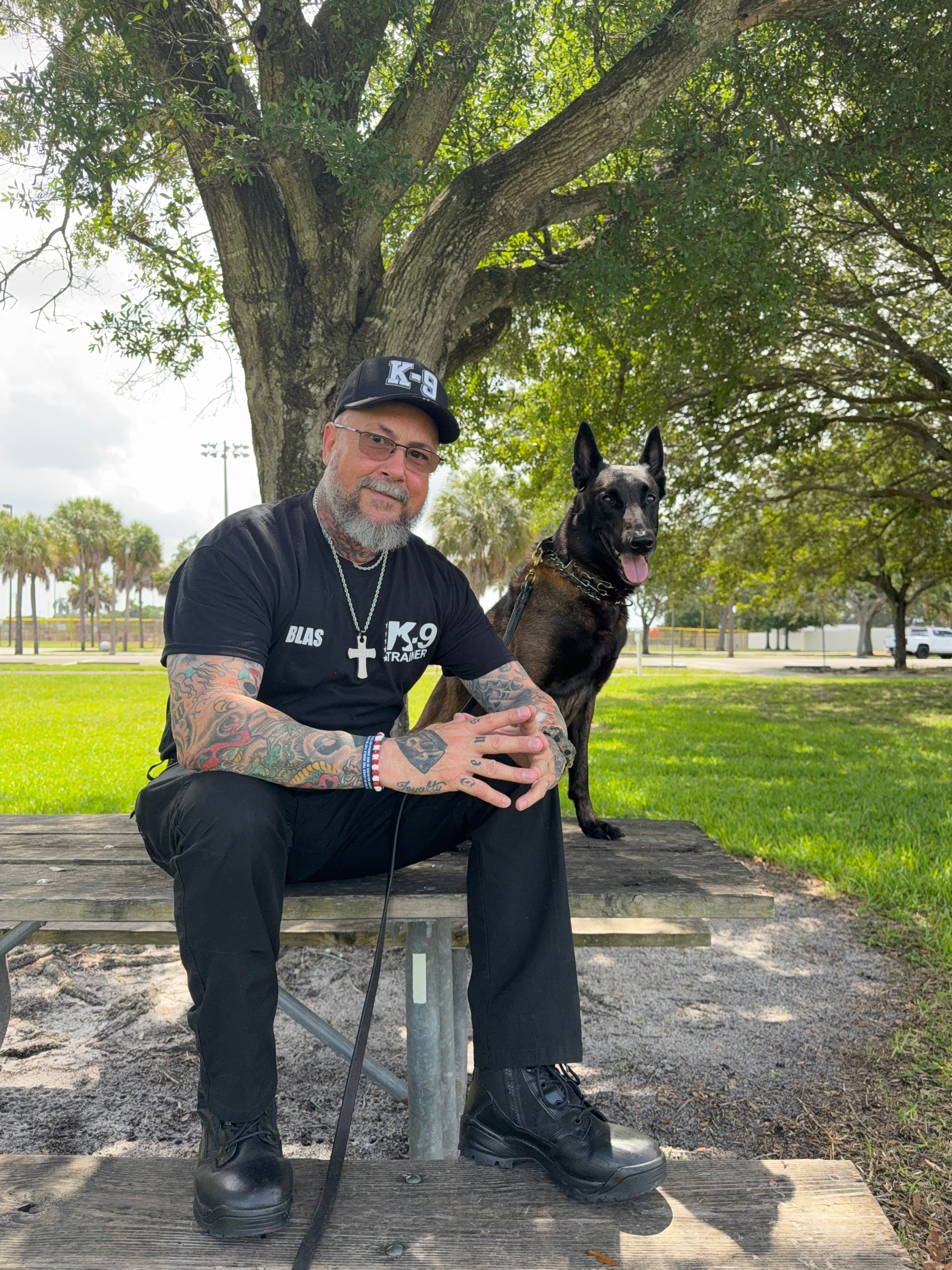 Blas L. Cardenas — dog psychologist and trainer sitting with his dog outdoors